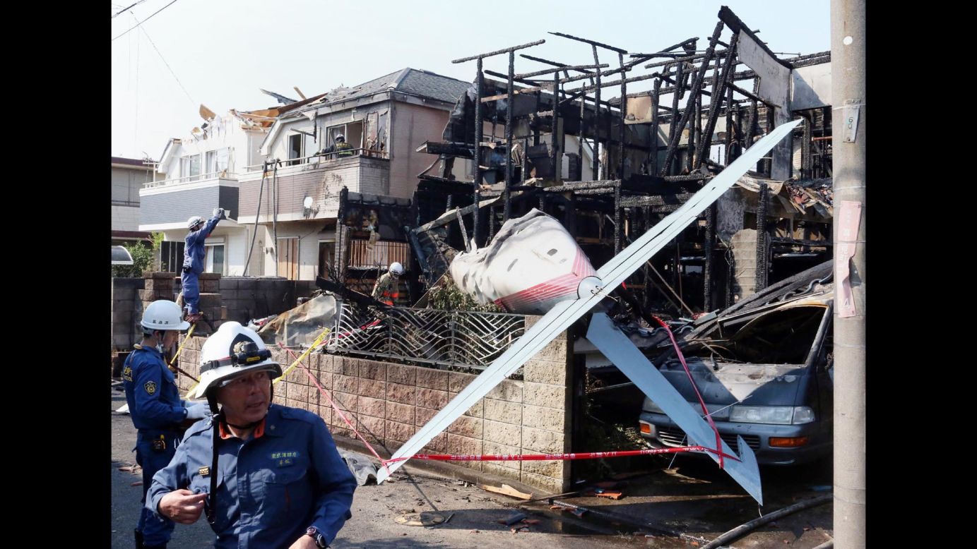 Firefighters inspect a house that was destroyed when <a href="http://www.cnn.com/2015/07/26/asia/tokyo-plane-crash/index.html" target="_blank">a small plane crashed into a residential area</a> in Chofu, Japan, on Sunday, July 26. Three people were killed.