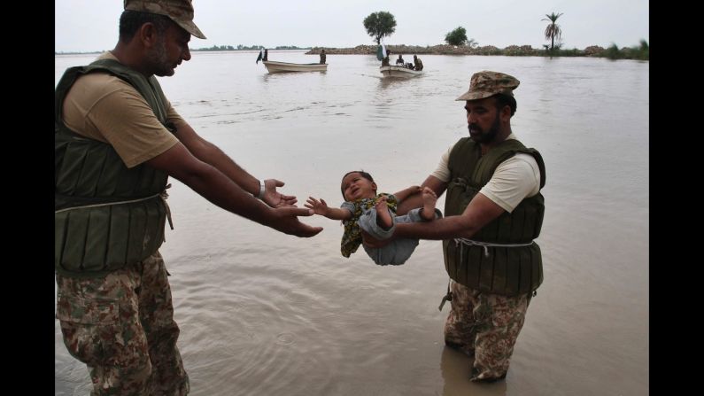 Members of the Pakistani Army rescue a young flood victim in Layyah, Pakistan, on Monday, July 27.