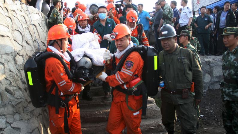 Rescuers carry miners out of a flooded coal mine in Hegang, China, on Monday, July 27. A landslide on July 20 had trapped miners underground for days. Some of the miners were rescued, but others were confirmed dead and some were still missing, according to the Xinhua News Agency.