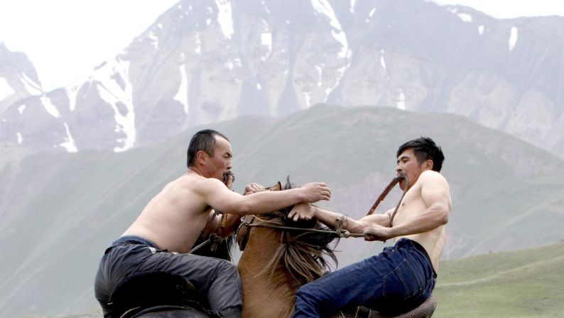 During Kyrgyzstan's national horse games, two men wrestle while riding horses on Saturday, July 25.