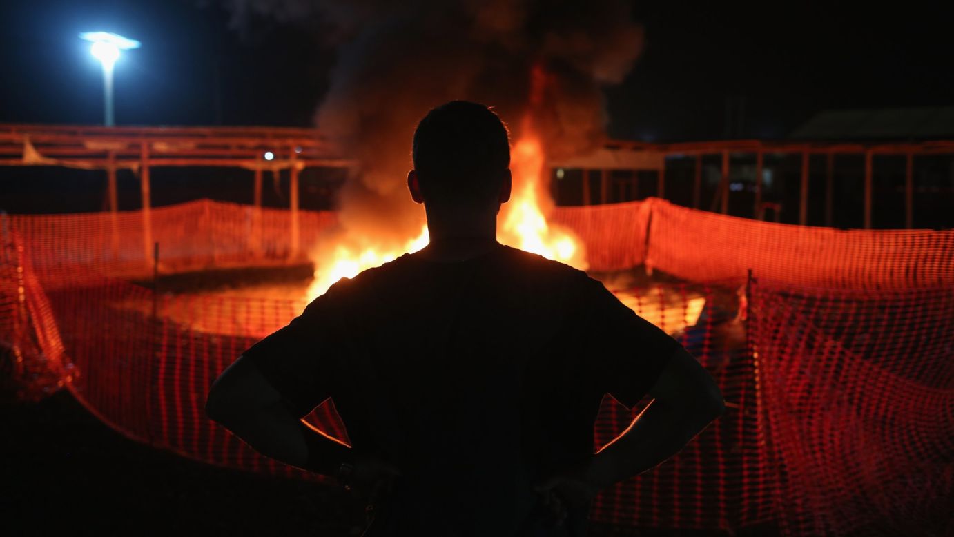 Doctors Without Borders staffer Alex Eilert Paulsen watches as mattresses and bed frames burn at the Ebola Treatment Unit in Paynesville, Liberia, on January 31, 2015. The organization reduced its number of beds from 250 to 30 as gains were made in battling the virus.