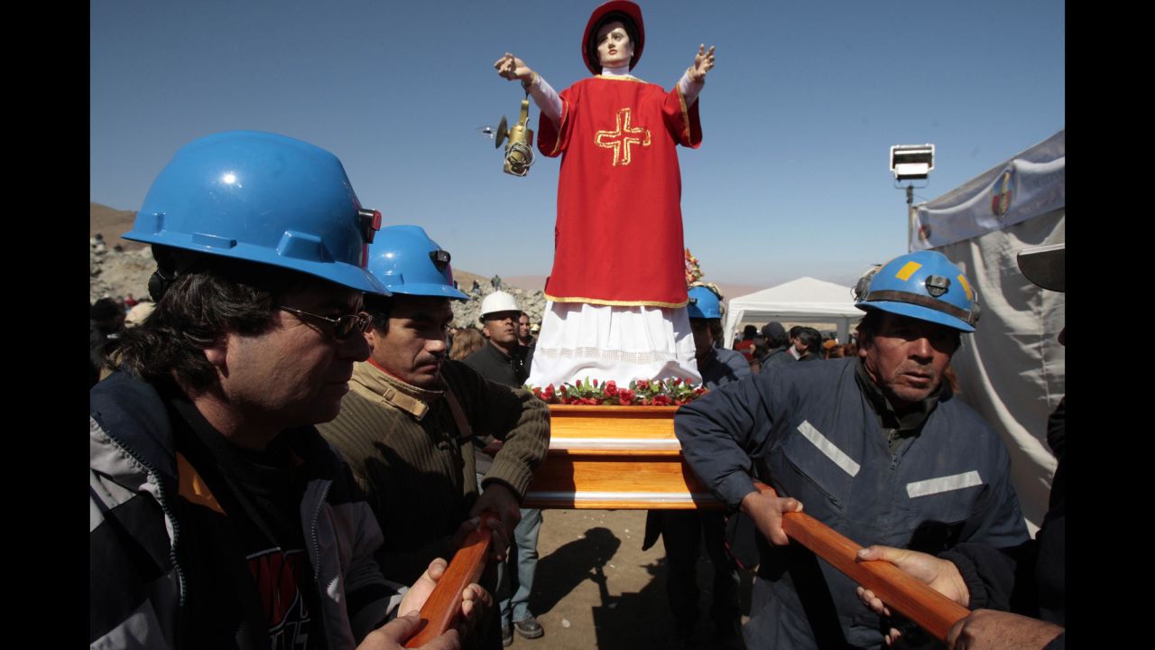 Miners carry an effigy of Saint Lorenzo, the patron saint of miners, before a Mass outside the collapsed mine on August 10.