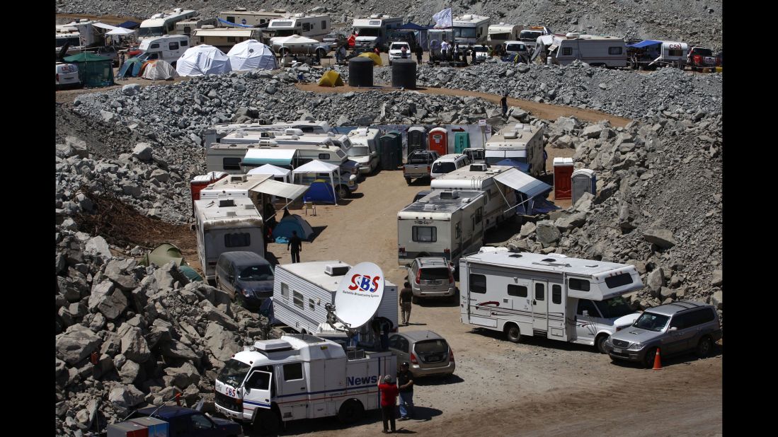 Media vehicles are parked on the outskirts of the mine on October 11.