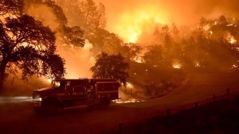 A Cal Fire truck is driven away from flames as the Rocky Fire burns near Clearlake on August 2.