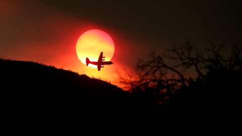 A firefighting air tanker flies in front of the setting sun while battling the Rocky Fire on August 1.