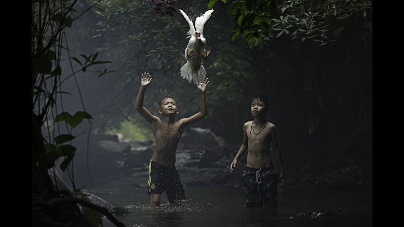 "Two boys are trying to catch a duck at the stream of the waterfall (in) Nong Khai Province, Thailand," Wouters said.