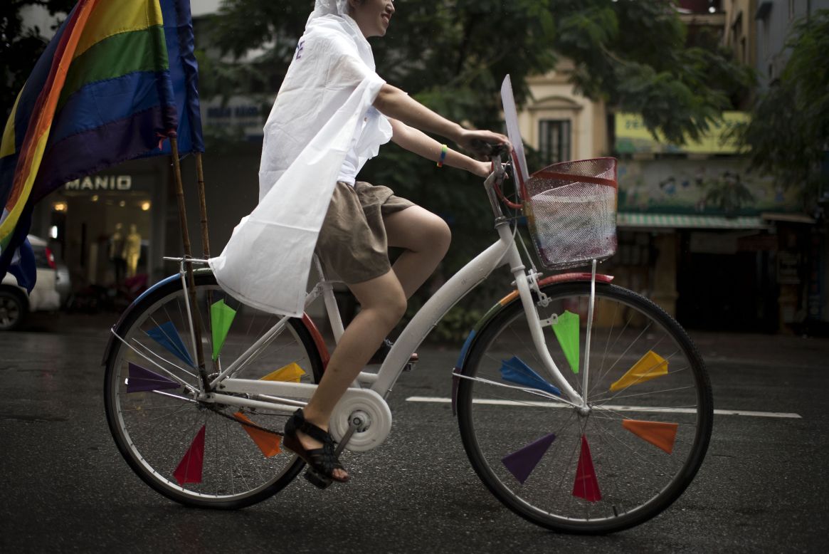A Vietnamese woman rides a bicycle decorated with rainbow flags at the bike rally on August 2 in Hanoi.