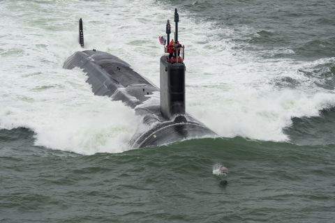 The request includes $5.2 billion to buy two Virginia-class attack submarines. Here, a dolphin swims in front of the USS John Warner during its sea trials in May.