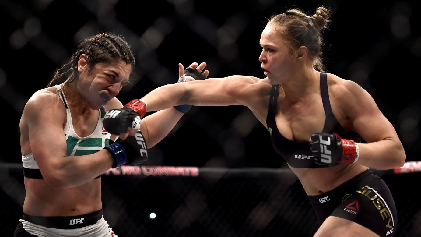 UFC champion <a href="http://www.cnn.com/2015/08/02/living/ronda-rousey-profile-feat/" target="_blank">Ronda Rousey</a>, right, punches Bethe Correia during their bantamweight title fight Sunday, August 2, in Rio de Janeiro. Rousey knocked out Correia in 34 seconds, improving her record to 12-0.