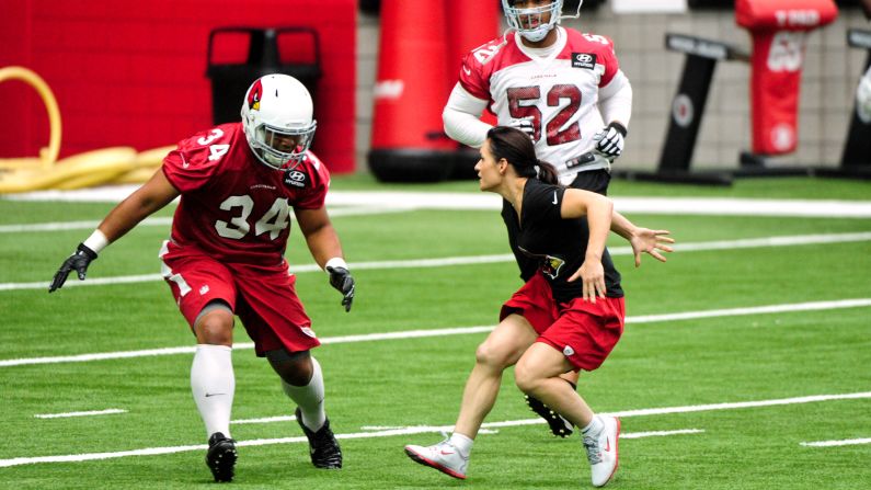 Jen Welter, <a href="index.php?page=&url=http%3A%2F%2Fwww.cnn.com%2F2015%2F07%2F28%2Fus%2Farizona-cardinals-hire-first-female-nfl-coach%2F" target="_blank">the NFL's first female coach</a>, works with running back Paul Lasike during the Arizona Cardinals' training camp Saturday, August 1.