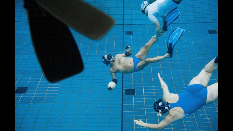 Swimmers play underwater rugby in the public pool at Berlin's Olympic Stadium on Wednesday, July 29. In underwater rugby, players try to place a ball filled with salt water into the basket of the opposing team.
