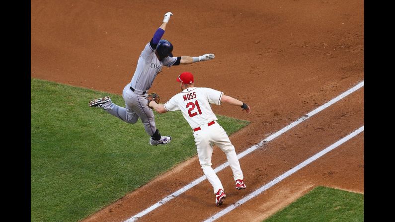 St. Louis' Brandon Moss tags out Colorado's Daniel Descalso during a Major League Baseball game in St. Louis on Saturday, August 1. Descalso played his first five seasons in St. Louis before signing with the Rockies in the offseason.