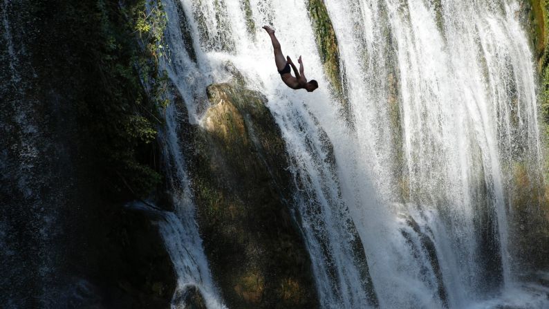 A competitor dives from a waterfall during a contest held in Jajce, Bosnia-Herzegovina, on Saturday, August 1.