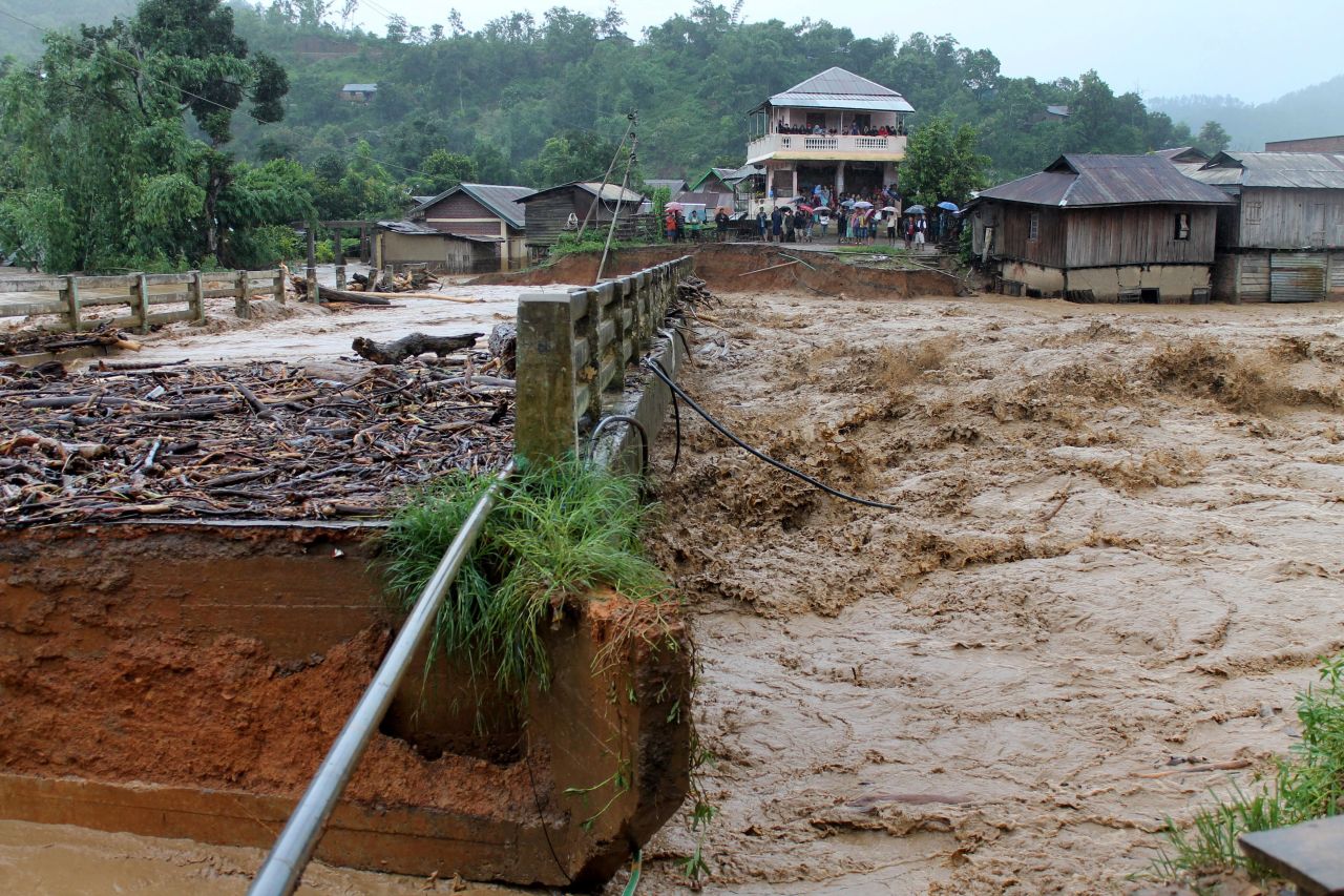 People look at a bridge which was washed away by floodwater in the state of Manipur, India on August 1, 2015. At least 178 have been killed in recent flooding, with an estimated 10 million affected across India.