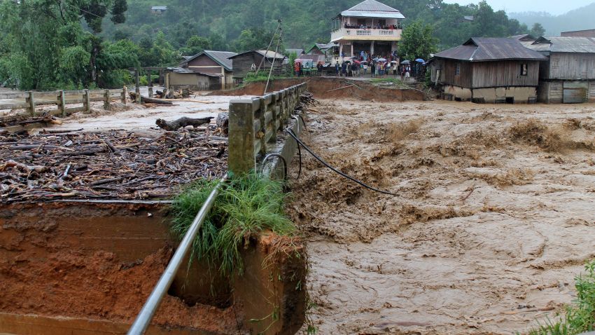 People look at the bridge which was washed away by the floodwaters in the state of Manipur, India on August 1, 2015. At least 21 people were killed in a landslide caused by heavy rains in Manipurs Chandel district, said police.
