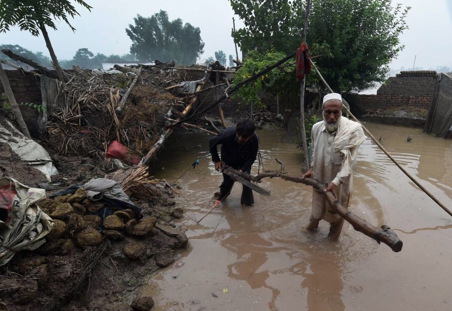 Pakistani men clear up next to a partially damaged house in the Khyber Pakhtunkhwa province on August 3, 2015. A spokesman for Pakistan's National Disaster Management Agency told AFP that 116 people had died and more than 850,000 people had been affected across the country by this year's monsoon floods.