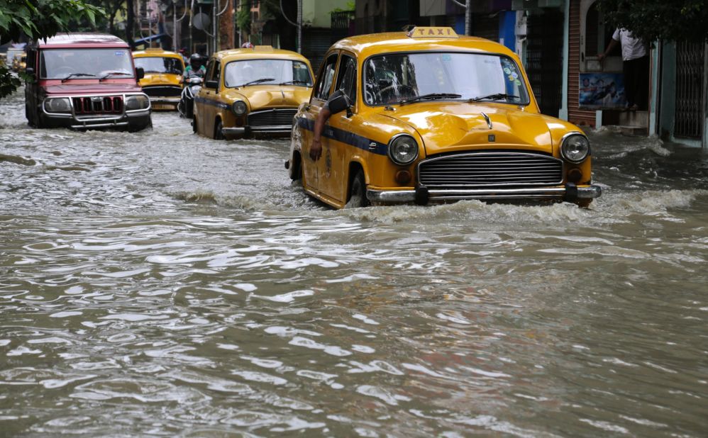 Yellow taxis and other vehicles wade through a flooded street in Kolkata, India, Sunday, Aug. 2, 2015. Parts of the city were flooded after the Ganges river rose following monsoon rains. 