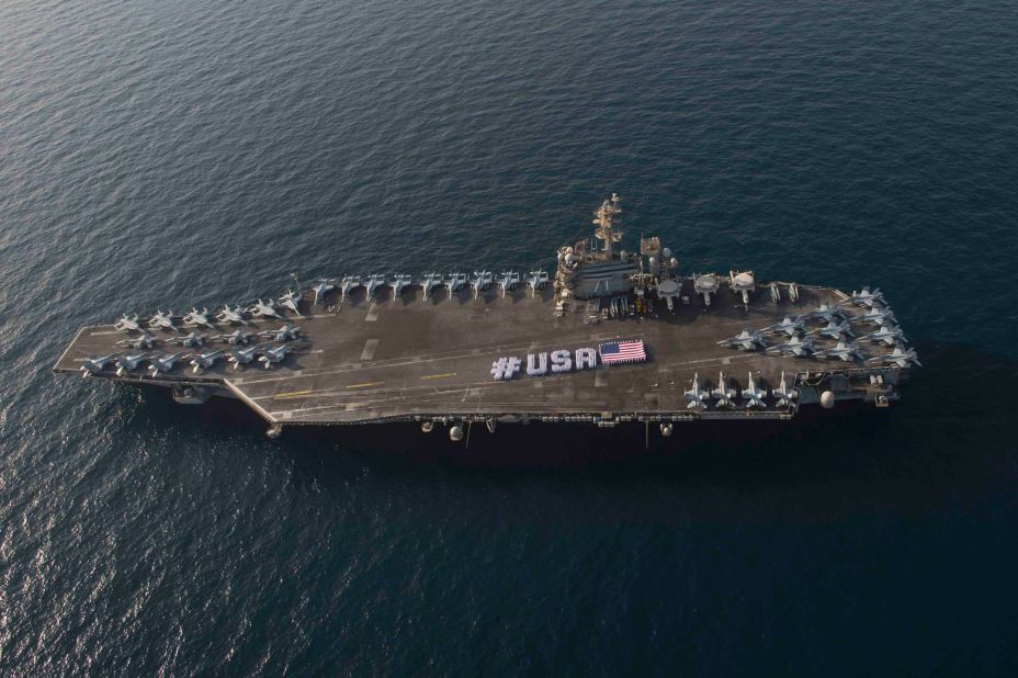 Sailors spell out #USA with the American flag on the flight deck of the Nimitz-class aircraft carrier USS Theodore Roosevelt in the Persian Gulf in late June 2015. When the Roosevelt leaves the Gulf sometime in October, the U.S. Navy will be without a carrier in the important region for two months.