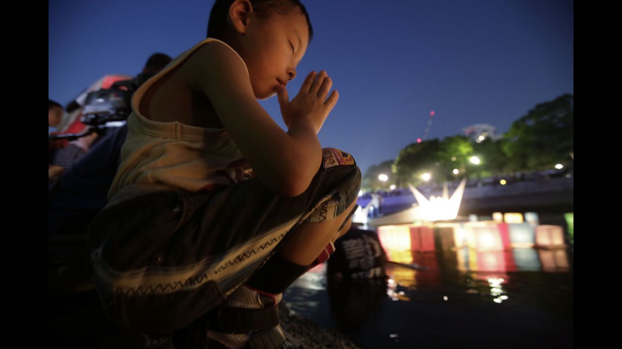 A boy offers prayer as after releasing a paper lantern into the Motoyasu River on August 6.