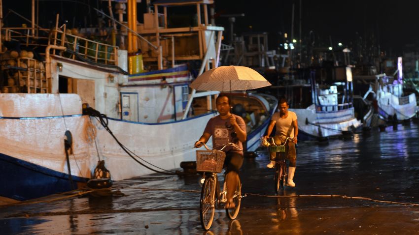 Workers ride past fishing boats moored in a shelter at Nanfangao harbour in Yilan on August 6, 2015 as typhoon Soudelor approaches eastern Taiwan. The strongest typhoon of the year was bearing down on Taiwan's east coast on August 6, forcing the evacuation of more than 2,000 from outlying islands popular with tourists. AFP PHOTO / Sam YehSAM YEH/AFP/Getty Images
