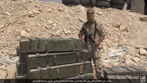 An ISIS fighter poses with spoils purportedly taken after capturing the Syrian town of al-Qaryatayn.