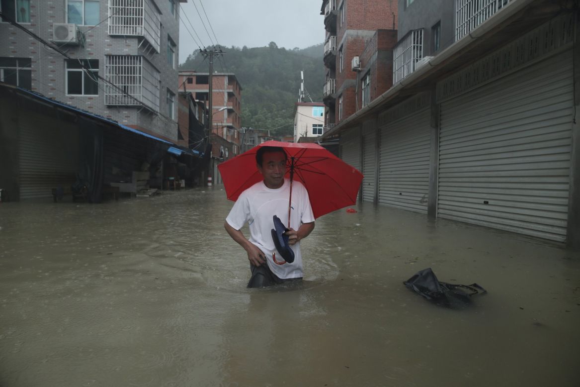 A man wades through a flooded street in Ningde, China, on Sunday, August 9. Soudelor made landfall Saturday night in the city of Putian, in China's southern Fujian province. More than 185,000 people moved to higher ground, Xinhua reported. The typhoon weakened as it moved inland toward the northwest.