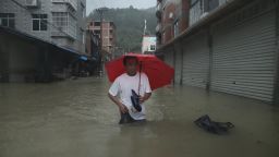 A resident wades through a flooded street in Ningde, China on Sunday August 9. A weakened Typhoon Soudelor made landfall in China, Sunday as it was downgraded to a tropical storm.