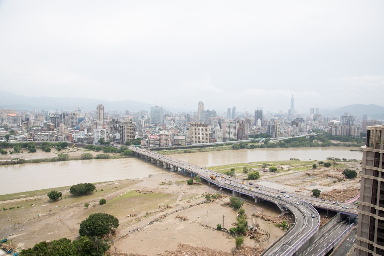 Piles of debris left by Typhoon Soudelor's heavy rain and flooding lie under the Zhongzheng Bridge as it crosses the Xindian River in Taipei. 