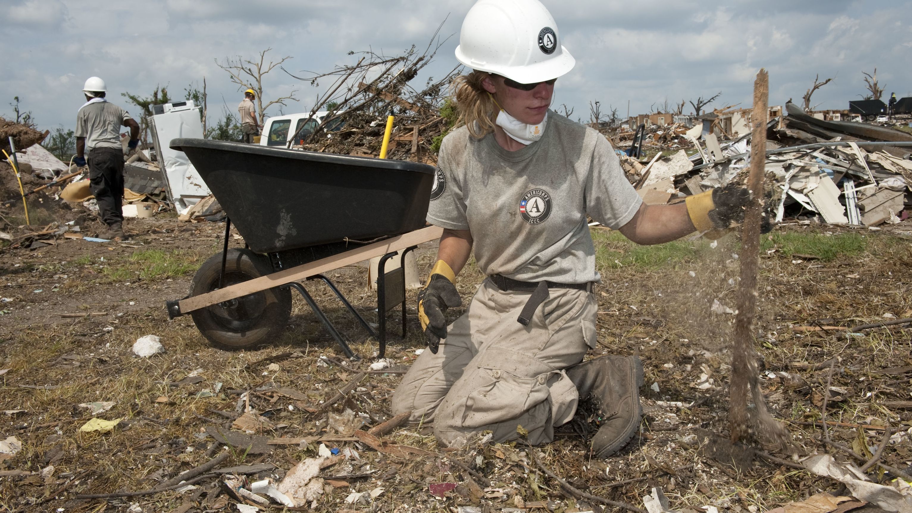 AmeriCorps volunteer Teri Jacobs picks up debris after a tornado in Joplin, Missouri, in June 2011.