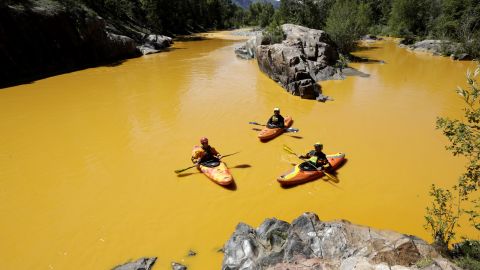 Kayakers float along the Animas River near Durango, Colorado, on August 6, in water colored from the mine waste spill. 