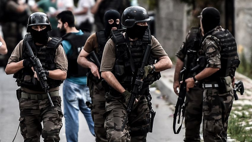 Turkish special force police officers take cover during clashes with attackers on August 10, 2015 at the Sultanbeyli district in Istanbul. Turkey's largest city Istanbul was Monday shaken by twin attacks on the US consulate and a police station as tensions spiral amid the government's air campaign against Kurdish militants. AFP PHOTO / OZAN KOSE        (Photo credit should read OZAN KOSE/AFP/Getty Images)