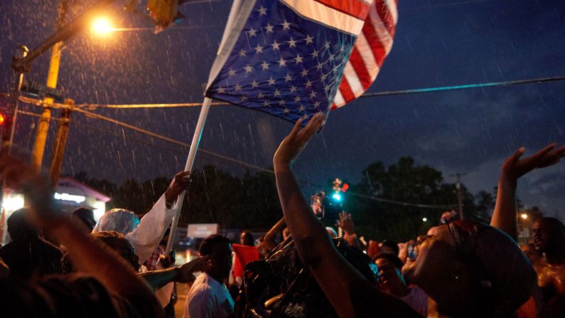 Protesters march in the rain in Ferguson on August 9.