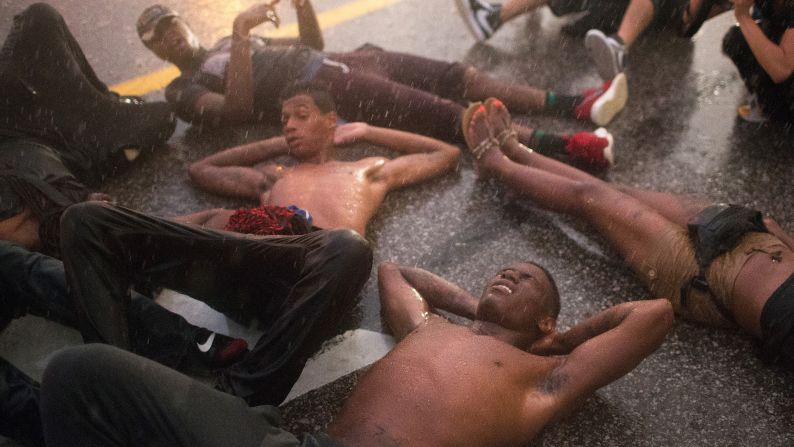 Demonstrators stage a "die-in" along West Florissant Avenue in Ferguson on August 9.
