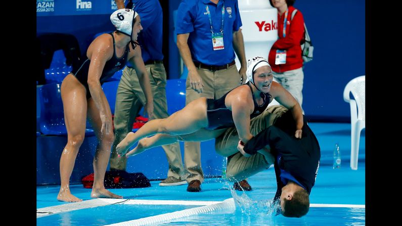 U.S. water polo players push head coach Adam Krikorian into the pool after they defeated the Netherlands in their women's water polo gold medal match during the Aquatics World Championships in Kazan, Russia, on Friday, August 7. 