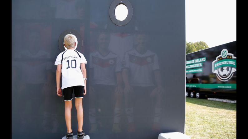 A young fan looks through a cutout in a team photo at the DFB Ehrenrunde on Friday, August 7, in Torgau, Germany. 