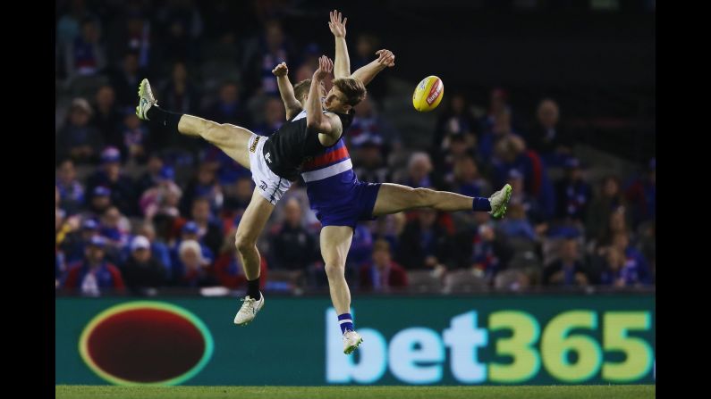 Hamish Hartlett of the Power, left, and Lachie Hunter of the Bulldogs compete for the ball during the round 19 AFL match between the Western Bulldogs and Port Adelaide Power on Saturday, August 8, in Melbourne.