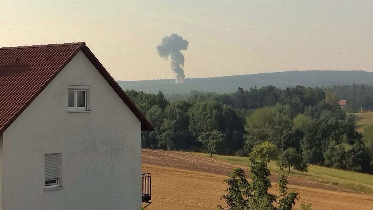 Smoke is visible in the distance where a U.S. F-16 crashed Tuesday in Germany's Bavaria region.