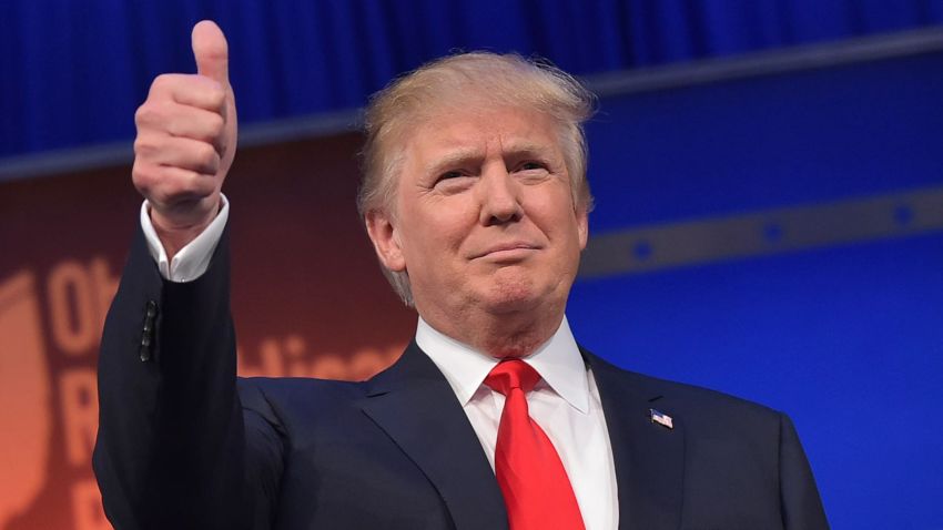 Donald Trump flashes a thumbs-up as he arrives for the start of the prime time Republican presidential debate on August 6, 2015 at the Quicken Loans Arena in Cleveland, Ohio.