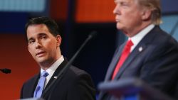 Republican presidential candidate Wisconsin Gov. Scott Walker (left) listens as Donald Trump fields a question during the first Republican presidential debate on August 6, 2015, in Cleveland, Ohio.