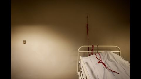 In the "Sixhour Room" lies a man under a blanket. Ertmann said that before six hours have passed from the moment of his death, a doctor will examine the body, looking for signs of clinical death such as bruising and stiffness. The red cord seen in this photo has never been used in the chapel in Aarhus, but it's<br />there anyway, so that the person under the cloth can call for help should they awaken.