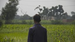 A boy who says he was molested and filmed looks across a field where he says many children, including him, were abused and raped in a story that has shocked Pakistan.