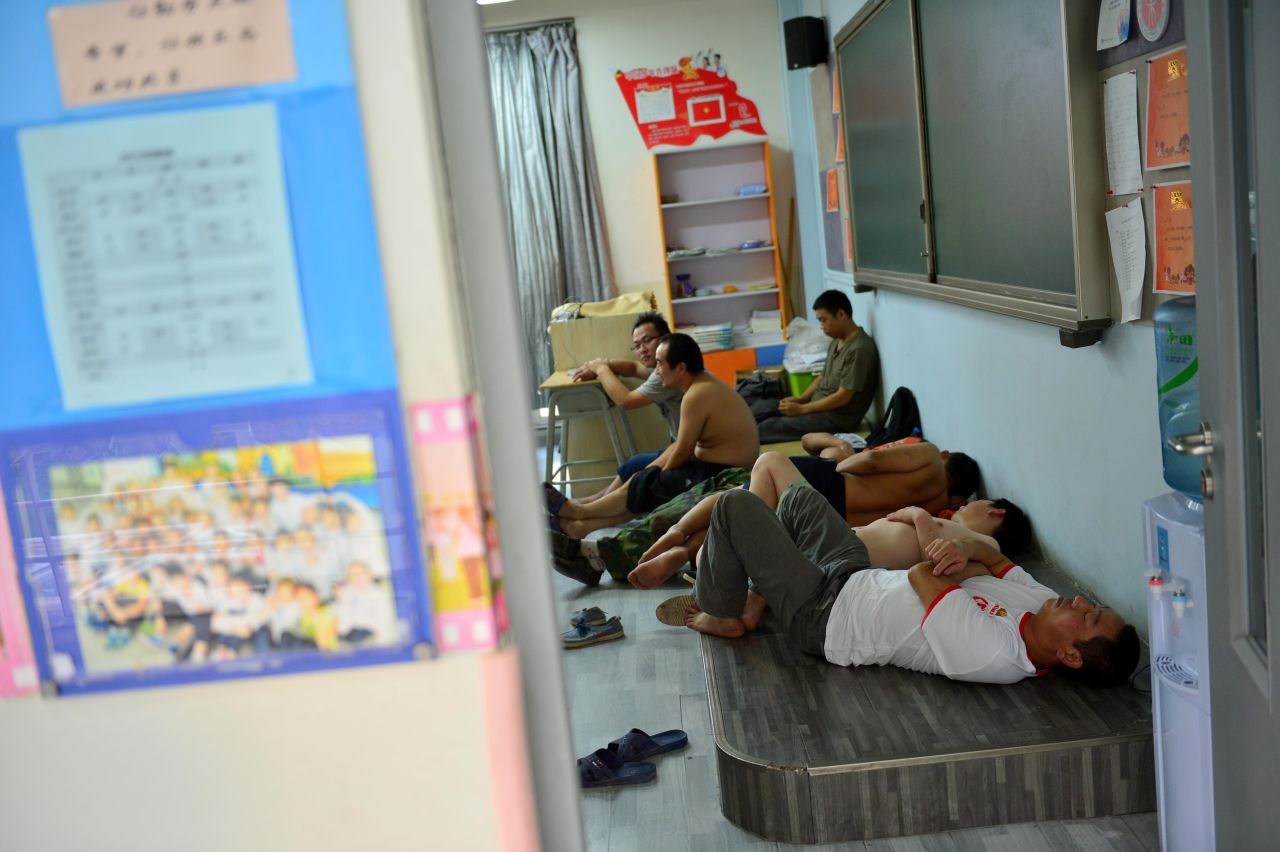 People sleep in a classroom at a primary school used as a makeshift emergency evacuation center.