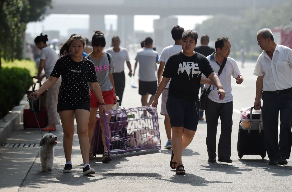 Residents take their belongings as they evacuate from parts of the city. Managers of the warehouse facility have provided "insufficient information" about what was stored there, a city safety official said, though it is known that sodium cyanide, a highly toxic chemical that can rapidly kill humans exposed to it, was one of the stored materials. <br />