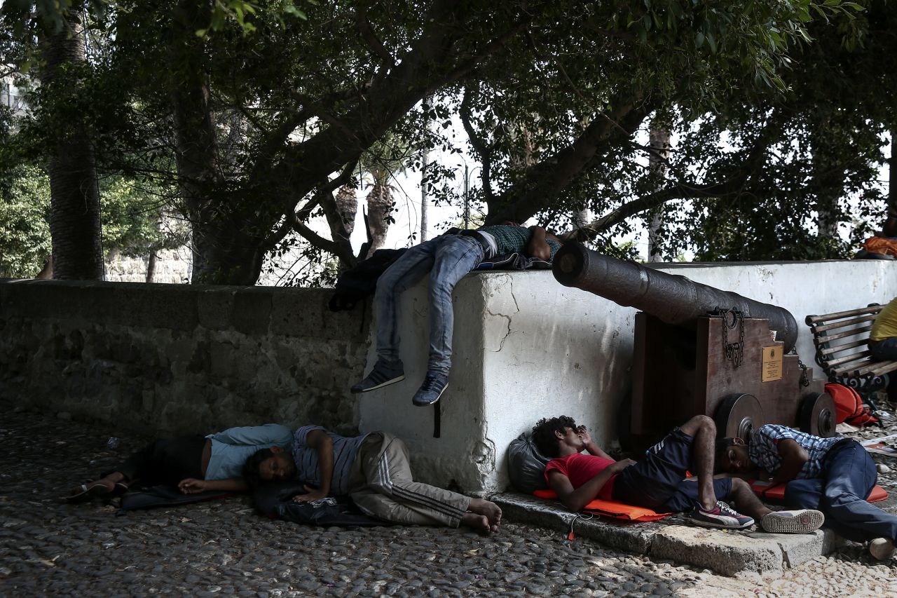 Migrants sleep in a central square of Kos on August 10. 