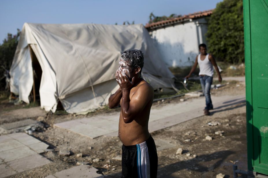 A man washes his face near a deserted hotel in Kos where hundreds of migrants found temporary shelter on August 10.
