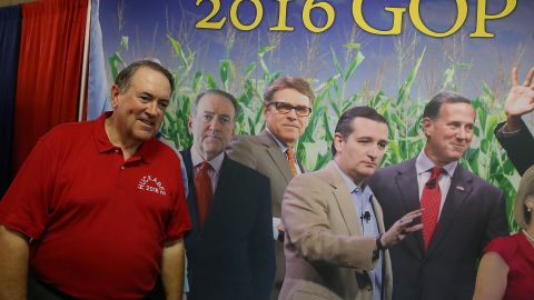 Huckabee stands next to a poster featuring all of the republican candidates for president as he tours the Iowa State Fair on August 13, 2015 in Des Moines, Iowa. 