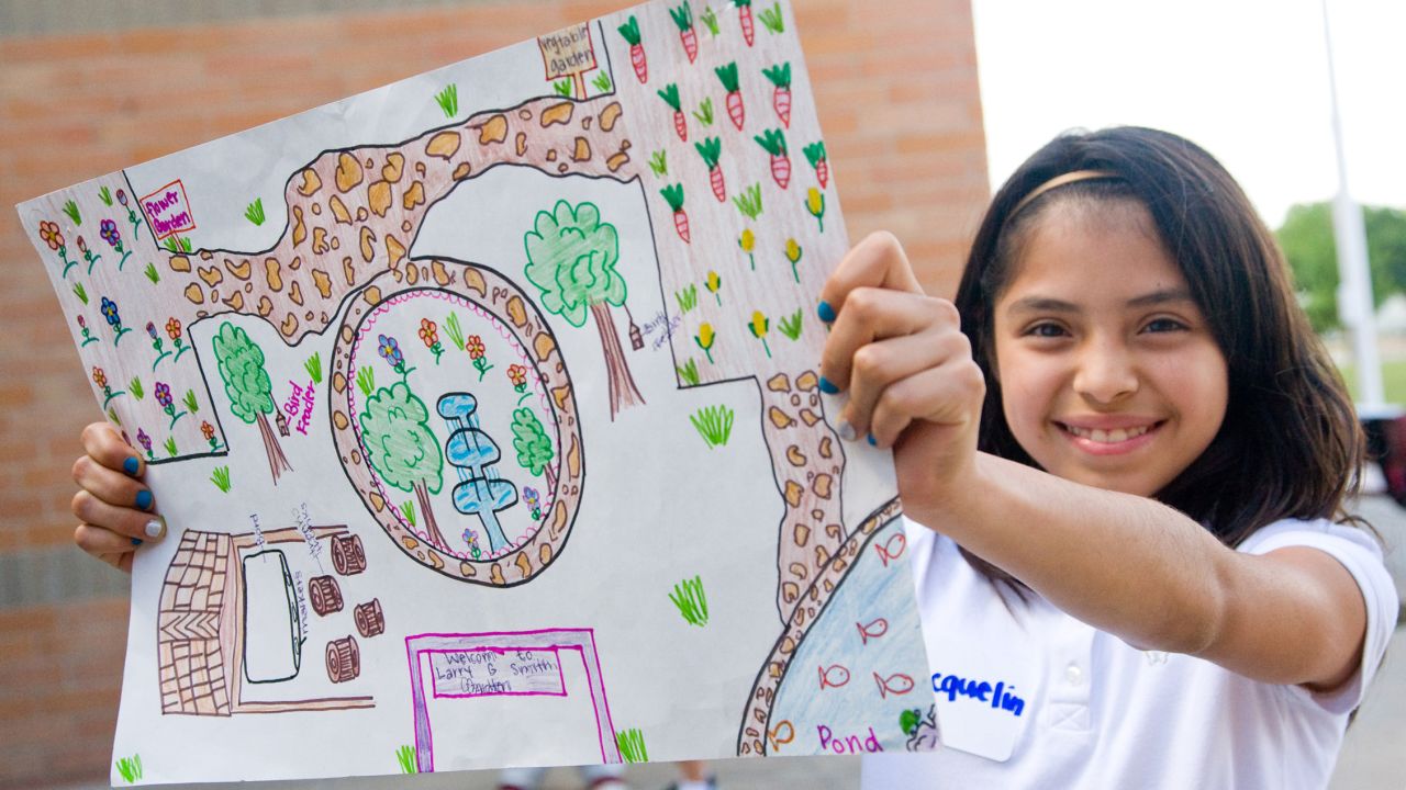 A student at Larry G. Smith Elementary School in Mesquite, Texas, shows off her design for a school garden. Click through our gallery to see more of the garden.