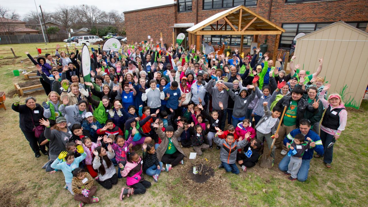 Students, parents and teachers at Sudie L. Williams Elementary School in Dallas, Texas, before the "Big Dig" with REAL School Gardens to build their school garden. They are joined by Blue Cross and Blue Shield of Texas employees.
