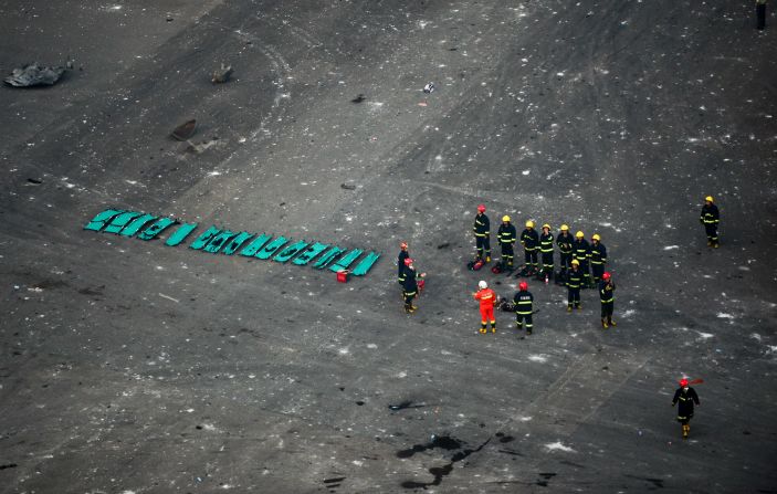 Rescuers are seen near the site of the blasts. A Chinese military team of nuclear and chemical were conducting investigations as pressure grew on authorities to explain the cause of the fire and the resulting cataclysmic explosions. 