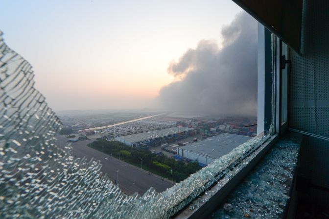 Fire and smoke is seen from a broken window of an apartment. 